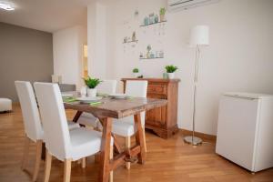 a dining room table with white chairs and a white refrigerator at Adriatico Home[Mare-Fiera-Centro] in Bari