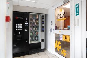 ein Verkaufsautomat in einem Geschäft neben einem Fenster in der Unterkunft Premiere Classe Meaux Nanteuil Les Meaux in Nanteuil-lès-Meaux