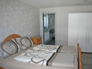 una camera da letto con un grande letto con lenzuola bianche di Ferienwohnung Christel a Schmallenberg