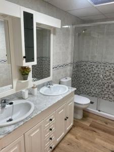 a bathroom with two sinks and a toilet and a shower at La Pita in Almería
