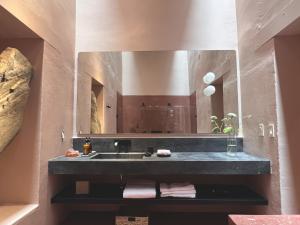 een badkamer met een wastafel en een grote spiegel bij Jr-Kiyo Estudios in Oaxaca City