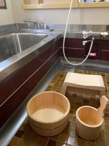 a bathroom with a sink and a wooden tub in the floor at 田舎庵 in Hanyu