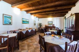 a dining room with tables and chairs and wooden ceilings at Agriturismo Villa Gaia in Càbras