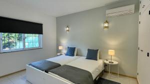 a bedroom with a bed and two lamps and a window at Nicola by Check-in Portugal in Albufeira