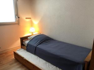1 dormitorio con 1 cama con lámpara. en SUNSET 3 pieces centre Moulleau 50 m de la plage, en Arcachon