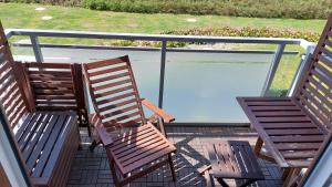 Duas cadeiras e uma mesa numa varanda com um lago em Nocleg u Kasi TRÓJMIASTO em Kowale