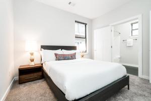 1 dormitorio blanco con 1 cama grande y 2 lámparas en CozySuites Music Row Spacious 1BR with free parking 45 en Nashville