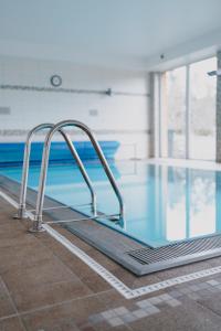 uma piscina com uma passagem de metal ao lado de uma piscina em OREA Resort Panorama Moravský kras em Blansko