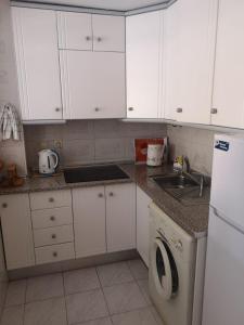 cocina con armarios blancos y lavadora en Suiza -Apartamento Viñamar en La Mata, en La Mata