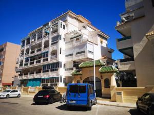 una furgoneta azul estacionada frente a un edificio en Suiza -Apartamento Viñamar en La Mata, en La Mata