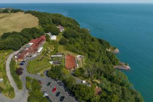 eine Luftansicht eines Hauses auf einem Hügel neben dem Wasser in der Unterkunft Sandy Cove Hotel in Ilfracombe