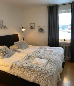 two beds in a hotel room with a window at Brinkeboda Wärdshus in Mörsil