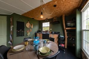 a dining room with a wooden table and green walls at 40, Theme Forest world - Dogs allowed! in Oisterwijk