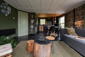 a living room with a couch and a table at 40, Theme Forest world - Dogs allowed! in Oisterwijk