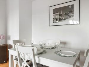 a dining room with a white table and chairs at Appartement familial Disney Val d'Europe La Vallée, wifi et parking in Serris