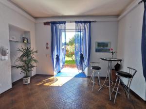 ノーリにあるAlbergo MP Noliのリビングルーム(青いカーテンとテーブル付きのドア付)