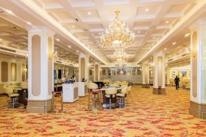 a hotel lobby with a chandelier and tables and chairs at The Venetian Hotel in Lusaka