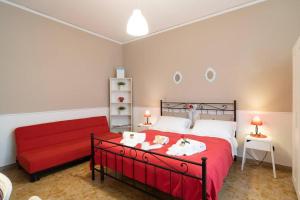 a bedroom with a red bed and a red couch at Terrazze Italiane City Center - RED APARTMENT in Verona