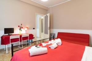 a bedroom with a red bed with white towels on it at Terrazze Italiane City Center - RED APARTMENT in Verona