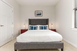 a bedroom with a large bed with blue pillows at CozySuites Music Row Spacious 2BR with free parking 55 in Nashville