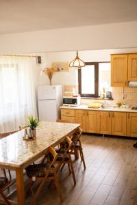 a kitchen with a table and chairs and a refrigerator at Casa Lotrilor in Malaia