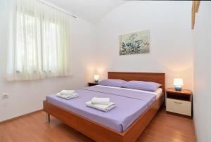sypialnia z łóżkiem i dwoma ręcznikami na nim w obiekcie Apartments Mira 1293 w Fažanie