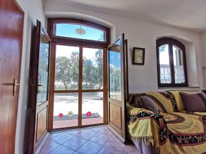 a room with a couch and a large glass door at Le Frasche di Marido holiday apartments in Alberese