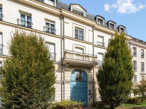 an apartment building with a blue door and trees at Appartement familial Disney Val d'Europe La Vallée, wifi et parking in Serris +8 photos