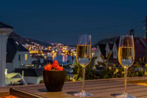 una mesa con dos copas de vino y un tazón de fresas en Big central apartment w/ a view and parking en Bergen