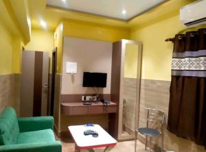 加爾各答的住宿－Hotel Moon Light，客厅配有绿色沙发和电视