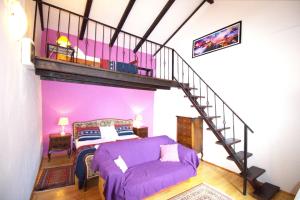 a bedroom with a purple bed and a spiral staircase at Beautiful Dalmatian Stone House with swimming pool in Jezera