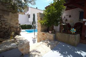 a house with a yard with a swimming pool at Beautiful Dalmatian Stone House with swimming pool in Jezera