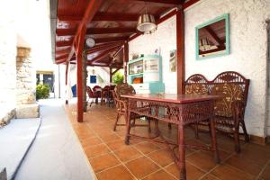 a patio with a table and chairs and a kitchen at Beautiful Dalmatian Stone House with swimming pool in Jezera