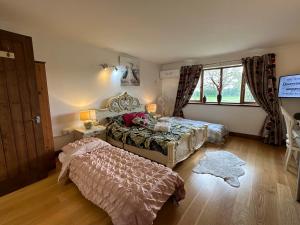 a bedroom with two beds and a window at Barnfields Retreat in Little Clacton