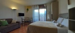 VitiniaにあるAlloggio turistico a Via Modugnoのベッドとソファ付きのホテルルーム