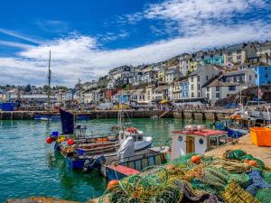 a group of boats docked in a harbor with buildings at White Sails in Brixham