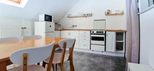 a kitchen with a wooden table and white cabinets at CinemApartman Eger in Eger