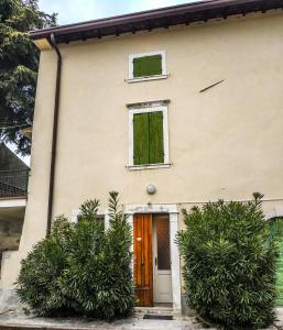 a white house with a door and two windows at Casale storico Enzo in Castelnuovo del Garda