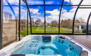 a hot tub in a house with a large window at Chalet 24 in Butgenbach