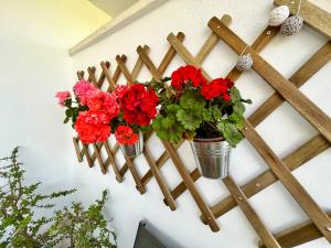 a wooden fence with flowers in buckets on a wall at Puerta del Cabo in Retamar