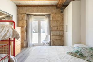 um quarto com uma cama, uma cadeira e uma janela em Casa en Dozón Centro de Galicia 