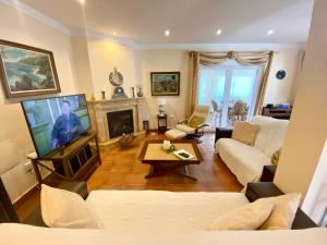 uma sala de estar com um sofá e uma televisão em Casa Nieves Cabo roig em Orihuela