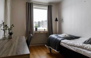 a bedroom with a bed and a table and a window at Brinkeboda Wärdshus in Mörsil