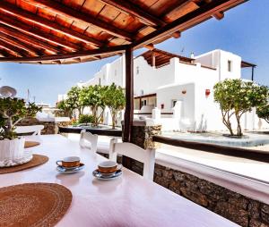 a table and chairs on a patio with a view of a house at Irene's Residence in Mikonos