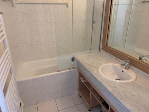 un bagno con lavandino, doccia e vasca di Appartement dans résidence de standing avec terrasse et vue mer a Le Pouliguen