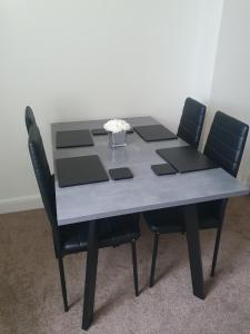 a table with four chairs and a bowl of flowers on it at Apartment in Failsworth in Manchester