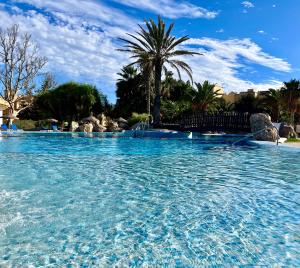 una gran piscina de agua azul en un complejo en Apartamentos Moguima, en Roquetas de Mar