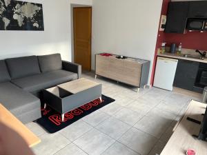 sala de estar con sofá y cocina en 1 appartement neuf centre flers accès facile proche gare et commodités, en Flers