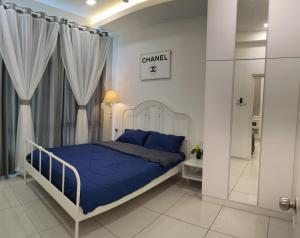 Schlafzimmer mit einem Bett mit blauer Decke in der Unterkunft D’Summit residences, Setia tropika , Johor Bahru in Johor Bahru