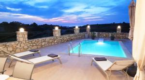 una piscina en la parte superior de un patio con sillas en Natural view villa with private pool, en Skouloúfia